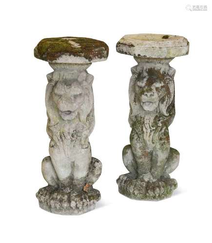 A pair of composite stone seated garden lions, 20th century,