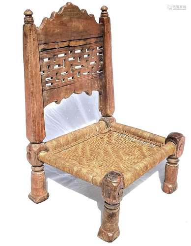 An Afghan carved wood low chair, 19th century, with a pierce...