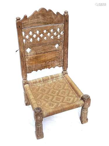 An Afghan carved wood low chair, 19th century, with a pierce...