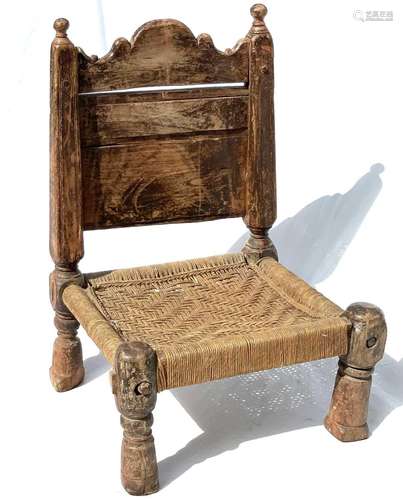 An Afghan carved wood low chair, 19th century, with a pierce...