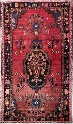 A North West Persian rug, the madder field with a central po...