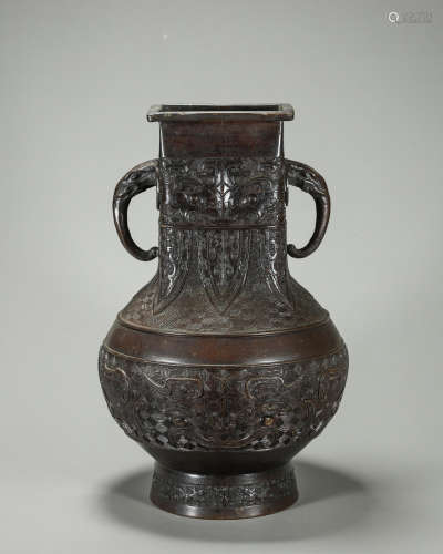 A taotie patterned copper vase with elephant head shaped ear...