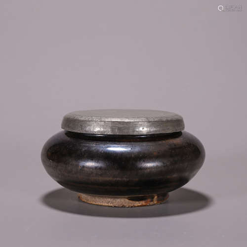 A black glazed porcelain jar with silver lid