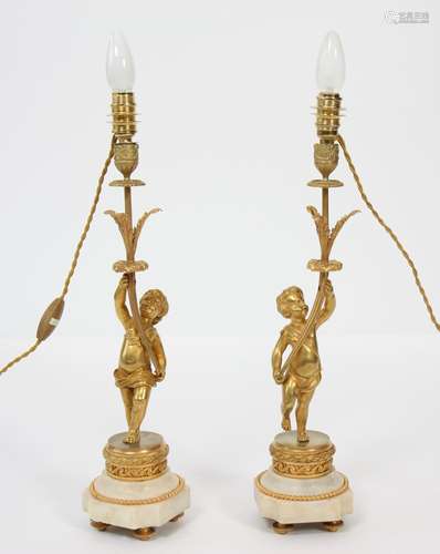 PAIRE DE LAMPES "AU PUTTO" EN BRONZE DORÉ<br />
À ...