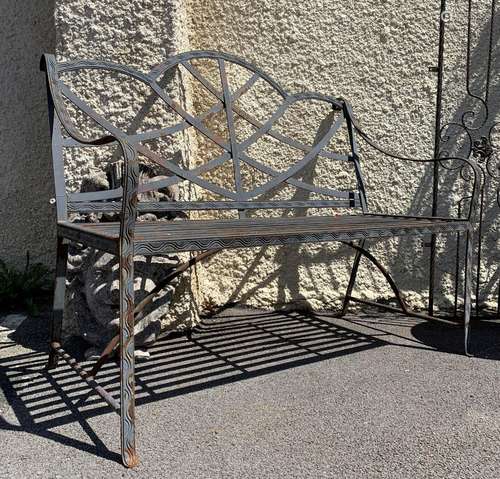 BANC DE JARDIN EN FER FORGÉ<br />
À assise et dossier ajouré...