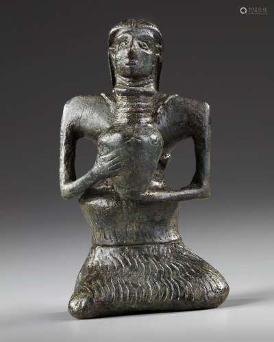 A BACTRIAN STATUETTE OF A SITTING FEMALE HOLDING A JAR, CIRC...