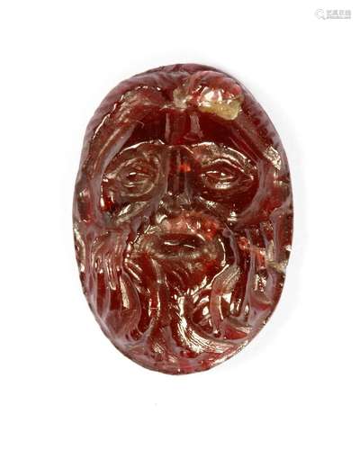 A ROMAN GARNET FACE OF ZEUS, CIRCA 2ND-3RD CENTURY A.D.