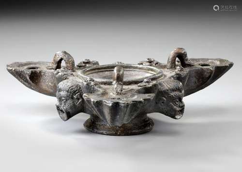 A ROMAN BRONZE THREE-NOZZLED OIL LAMP WITH THEATRE MASK AND ...