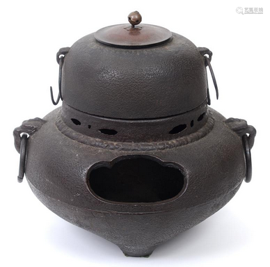 A metal Japanese tea kettle with bronze cover, of circular f...