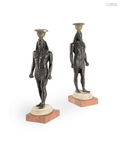 A PAIR OF BRONZE CANDLESTICKS IN THE FORM OF ANTINOUS AS OSI...