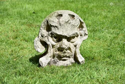 AN ANTIQUE LIMESTONE MASK WITH ROUGH CUT DECORATION, PROBABL...