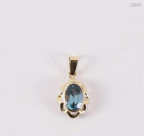 A 14 krt 585/1000 gold pendant with an oval facet cut blue s...