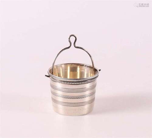 A silver spout strainer in the shape of a bucket with a pear...