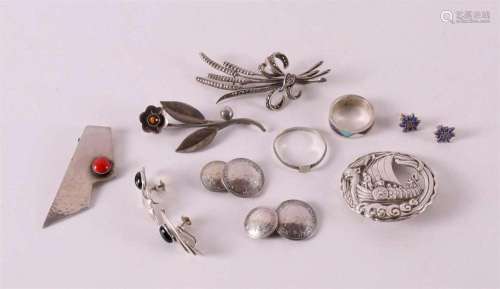 A lot of silver jewelry, including a Viking ship brooch and ...