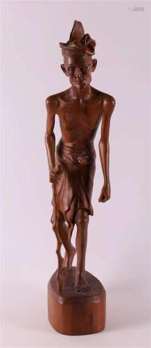 A carved wooden Indonesian man, signed Widhya Bakem, Indones...