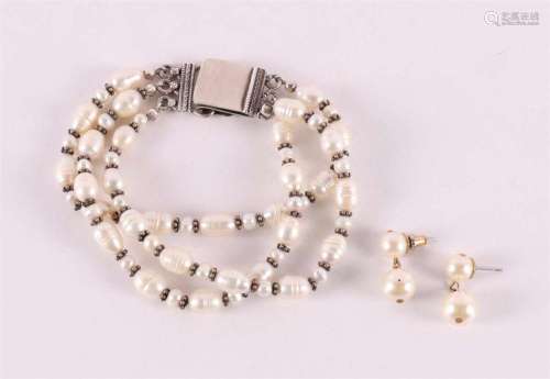 A pearl bracelet with a silver clasp.