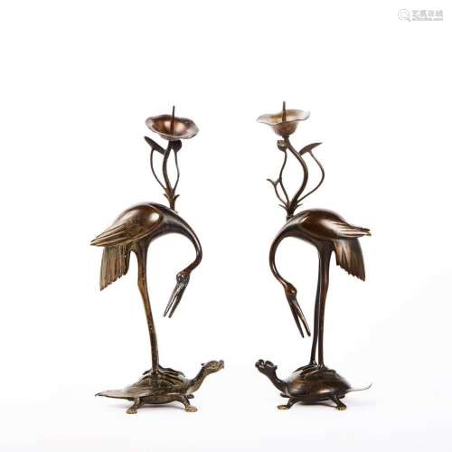 Paire de flambeaux en bronze patiné figurant des ibis juchés...