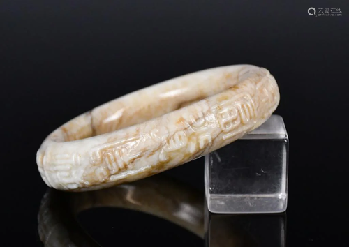 A Carved Buff-Colored Jade Bracelet