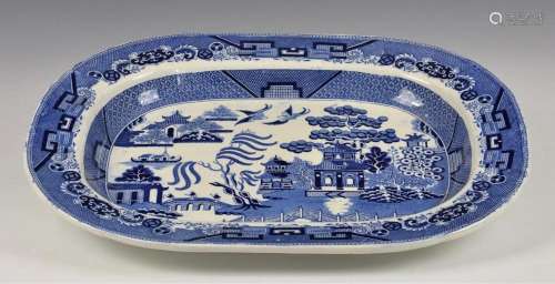 A large blue and white Willow pattern meat platter of typica...