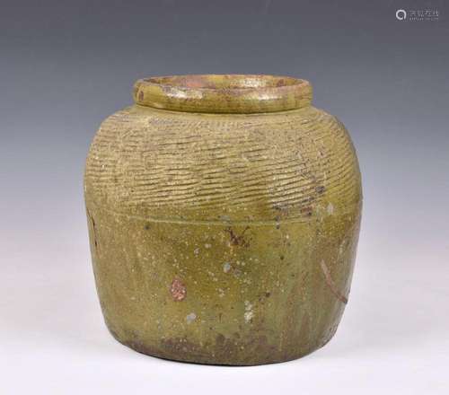 A large antique olive green glazed stoneware jar having an o...