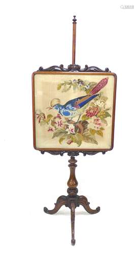 A Victorian mahogany pole embroidered fire screen with exoti...