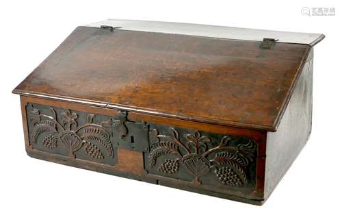 A 17th century oak bible box / desk, the front carved with t...