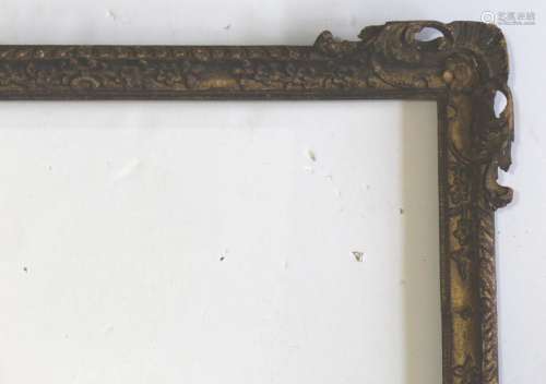 A CARVED AND GILDED PICTURE FRAME the corners with pierced l...