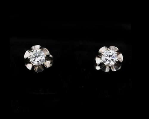 A pair of 14 karat white gold solitaire stud earrings set wi...