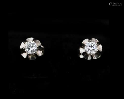 A pair of 14 karat white gold solitaire stud earrings set wi...