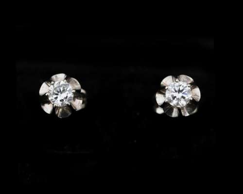A pair of 14 karat white gold solitaire stud earrings set wi...