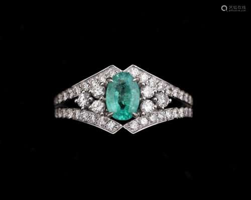 An 18 karat white gold ring centrally set with emerald and d...