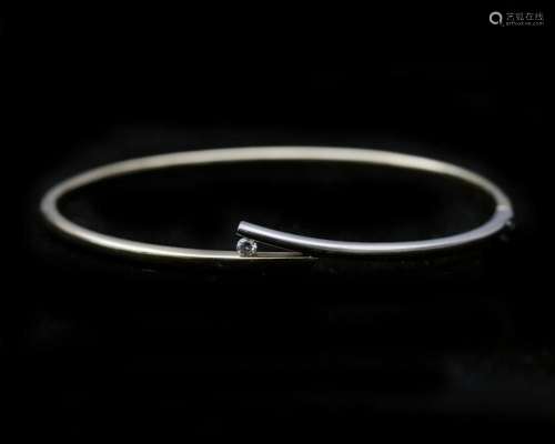 A 14 karat bicolor solid yellow and white gold bangle, set w...