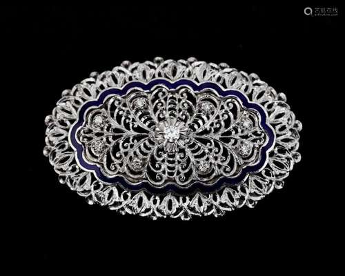 An 18 karat white gold in floral decor openwork oval brooch