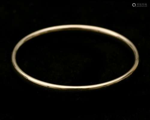 A 14 karat gold bangle