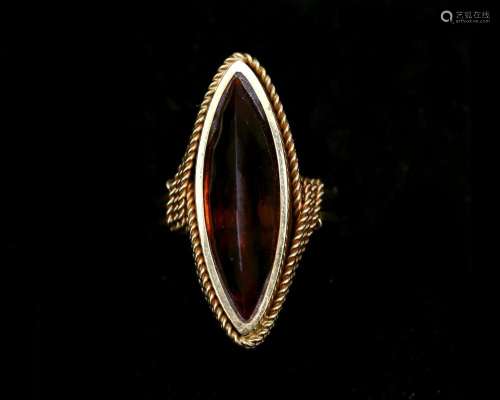 An 18 karat gold marquis ring set with a faceted cut amber