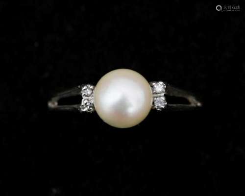 An 18 karat white gold ring, set with a cultured pearl and d...