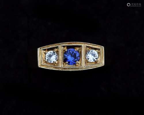 A 14 karat gold ring, set in the middle with a synthetic blu...