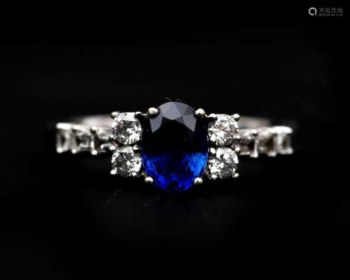 An 18 karat white gold ring set with an oval cut sapphire an...