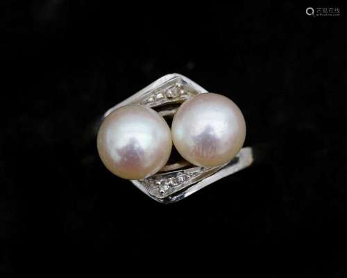 An 18 karat white gold ring set with two Akoya pearls approx...