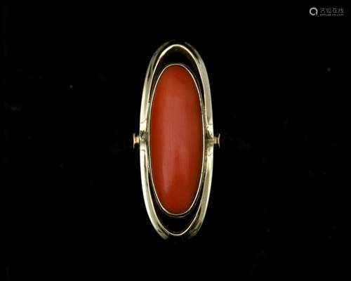 A 14 karat gold ring with oval cut red coral