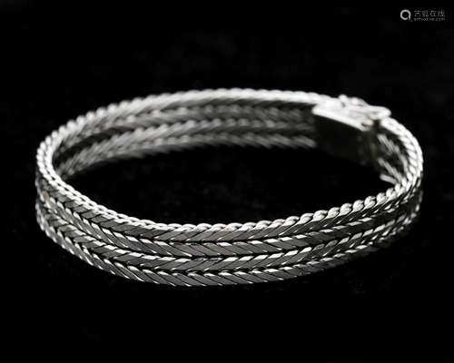 A 14 karat white gold braided bracelet