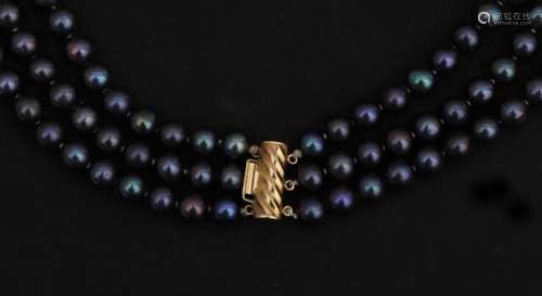 A three-part black pearl neckless with gold lock