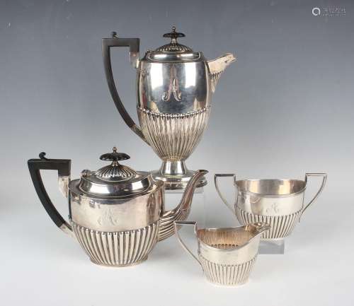 A George V silver four-piece tea set of oval half-reeded for...