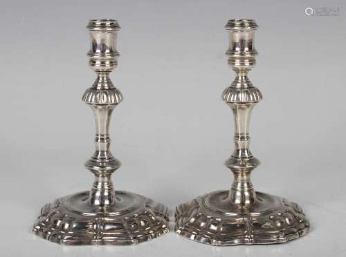 A pair of George II silver tapersticks, each cylindrical sco...
