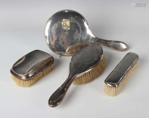 A George V silver three-piece dressing table set with engrav...