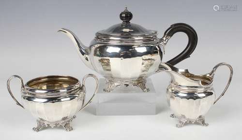 A George V silver three-piece tea set of circular faceted fo...