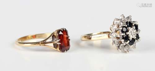 A gold ring, claw set with a rectangular cut garnet, detaile...