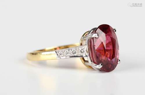 An 18ct gold ring, claw set with an oval cut pink tourmaline...