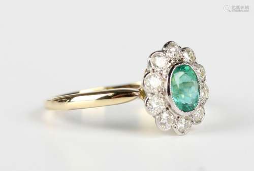 A gold, emerald and diamond oval cluster ring, collet set wi...