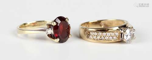 A gold, garnet and diamond three stone ring, claw set with t...